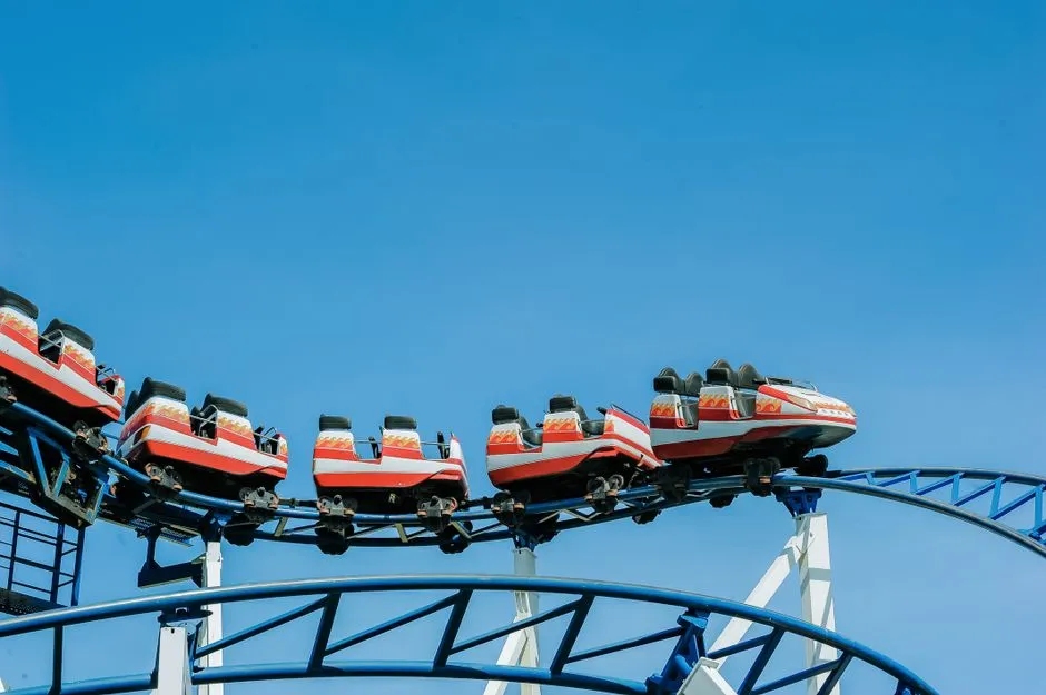 Steel roller coaster track and lift hill against a blue sky